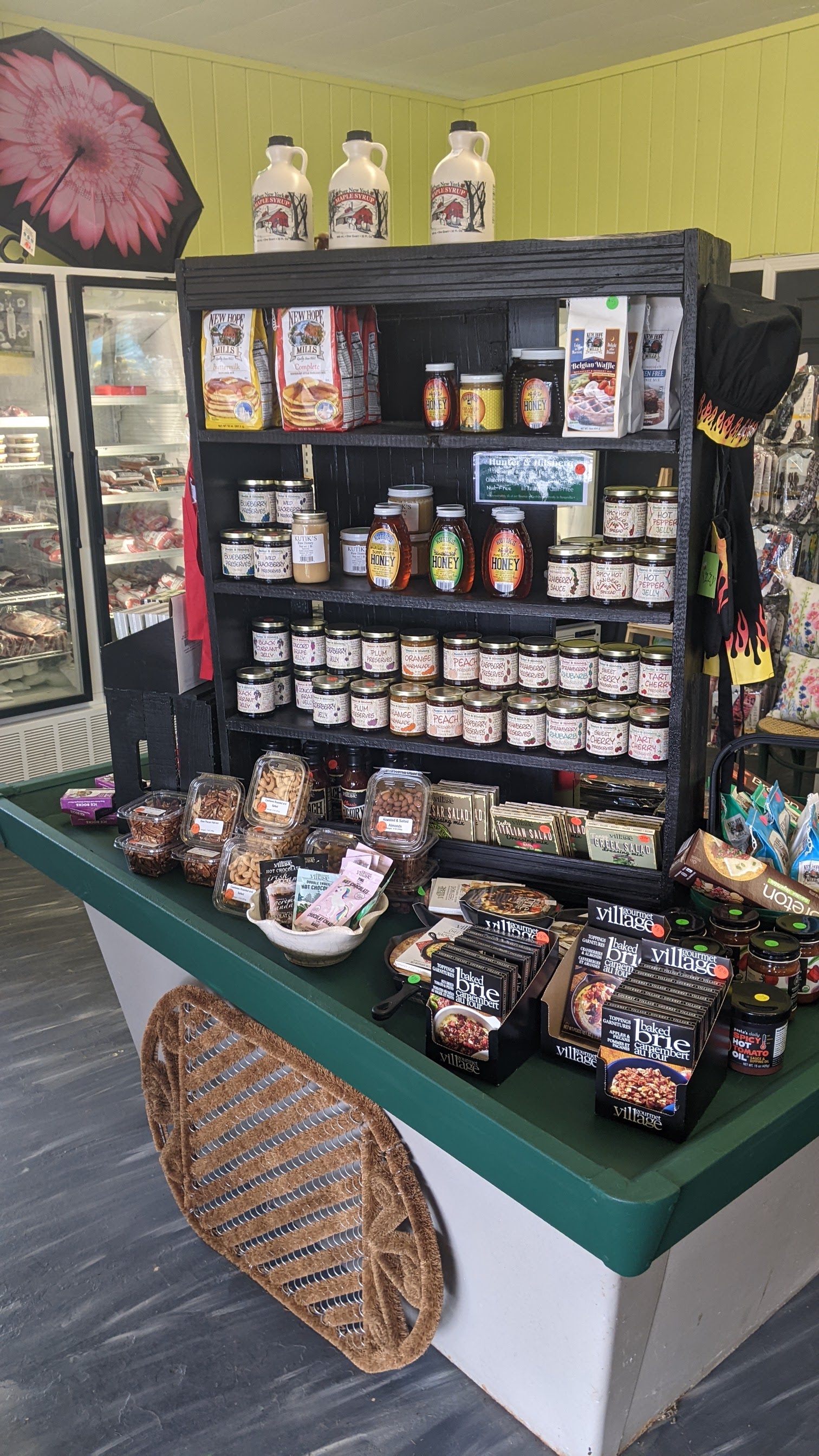 Market shelves with honey, syrups, and local goods